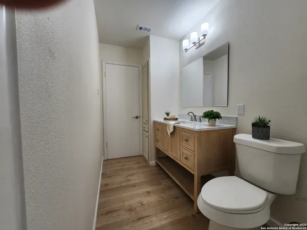 a bathroom with a granite countertop toilet sink and mirror