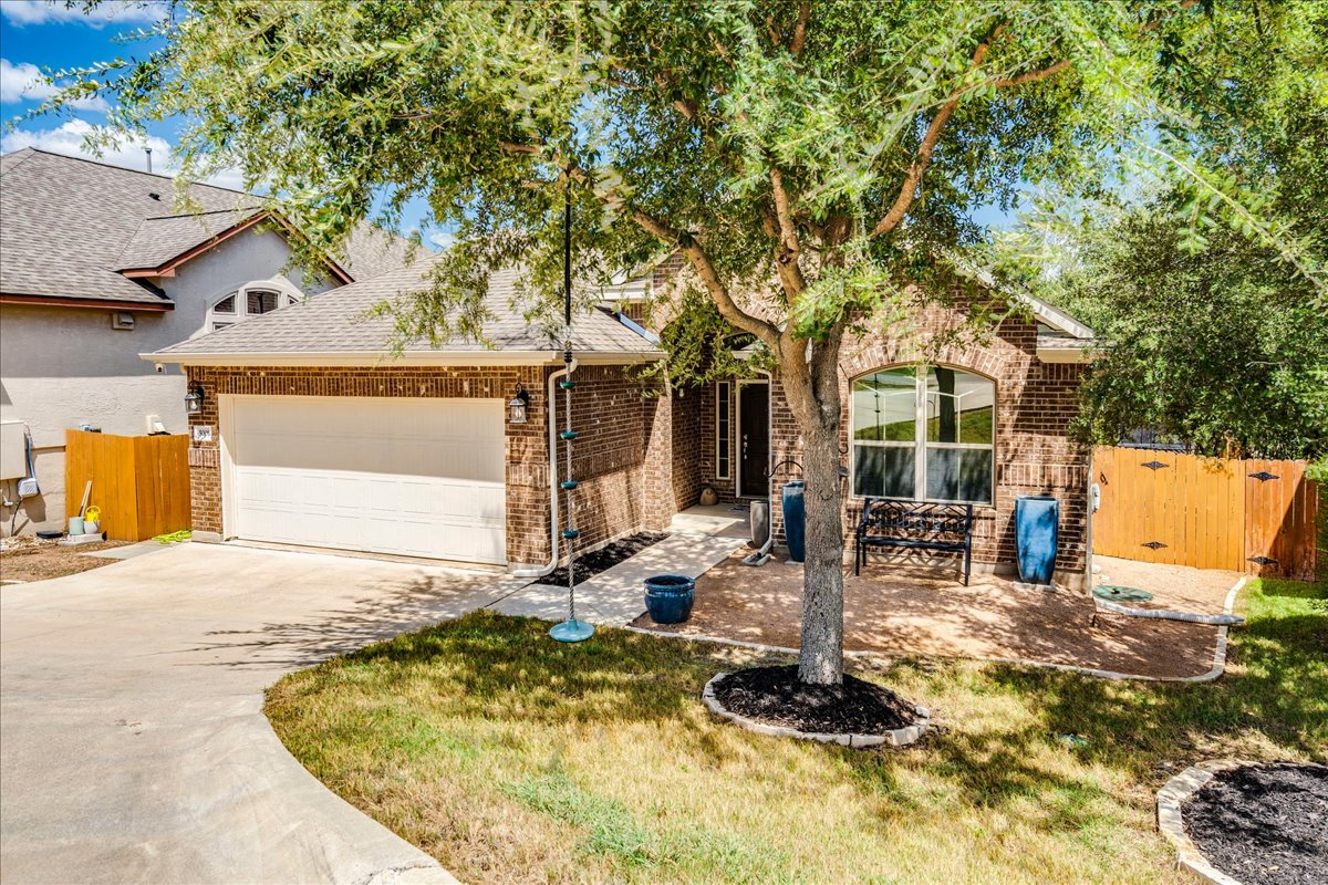 5009 Inks Clearing Lane Austin, TX 78738 - Photo 3 of 34 Mature trees shade the classic brick exterior of this welcoming home.