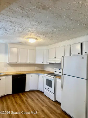 a kitchen with granite countertop a sink stove and refrigerator