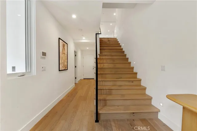 a view of entryway and hall with wooden floor