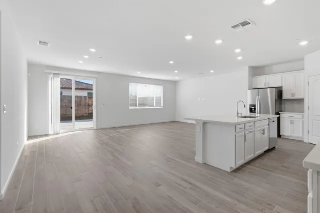 a kitchen with white cabinets and a window