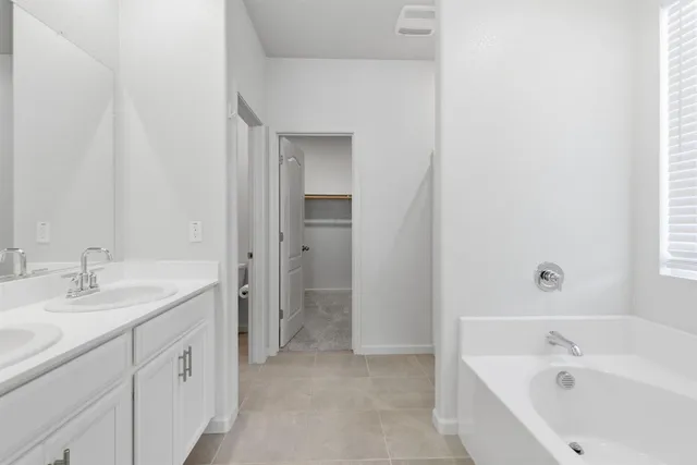 a bathroom with a tub sink and mirror