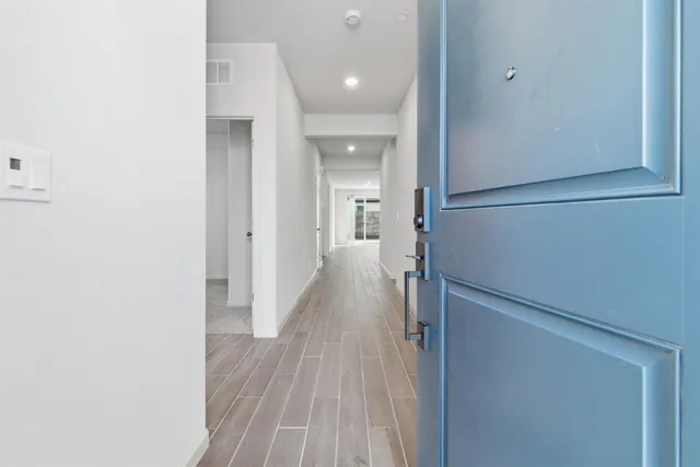 a view of a hallway with wooden floor