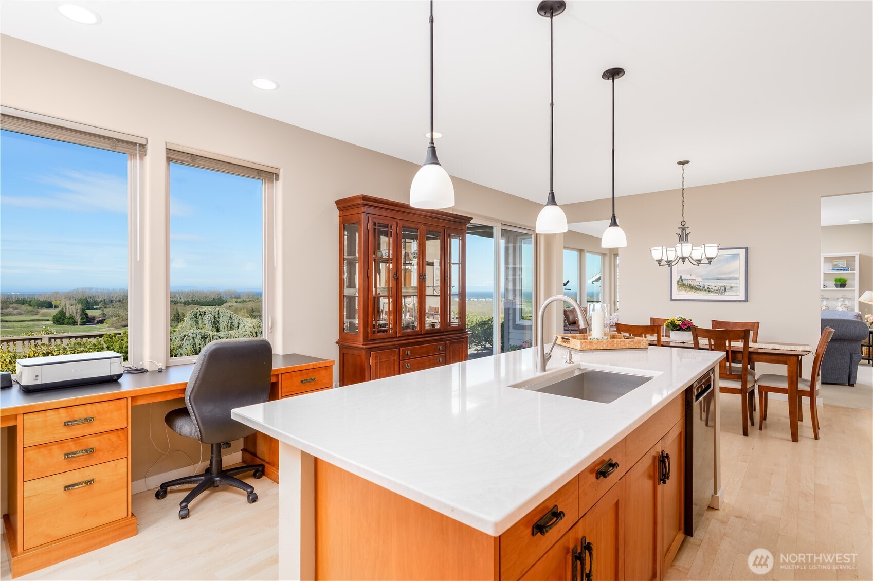 771 Brigadoon Boulevard Sequim, WA 98382 - Photo 19 of 40 a view of a kitchen with kitchen island a dining table chairs and a wooden floor