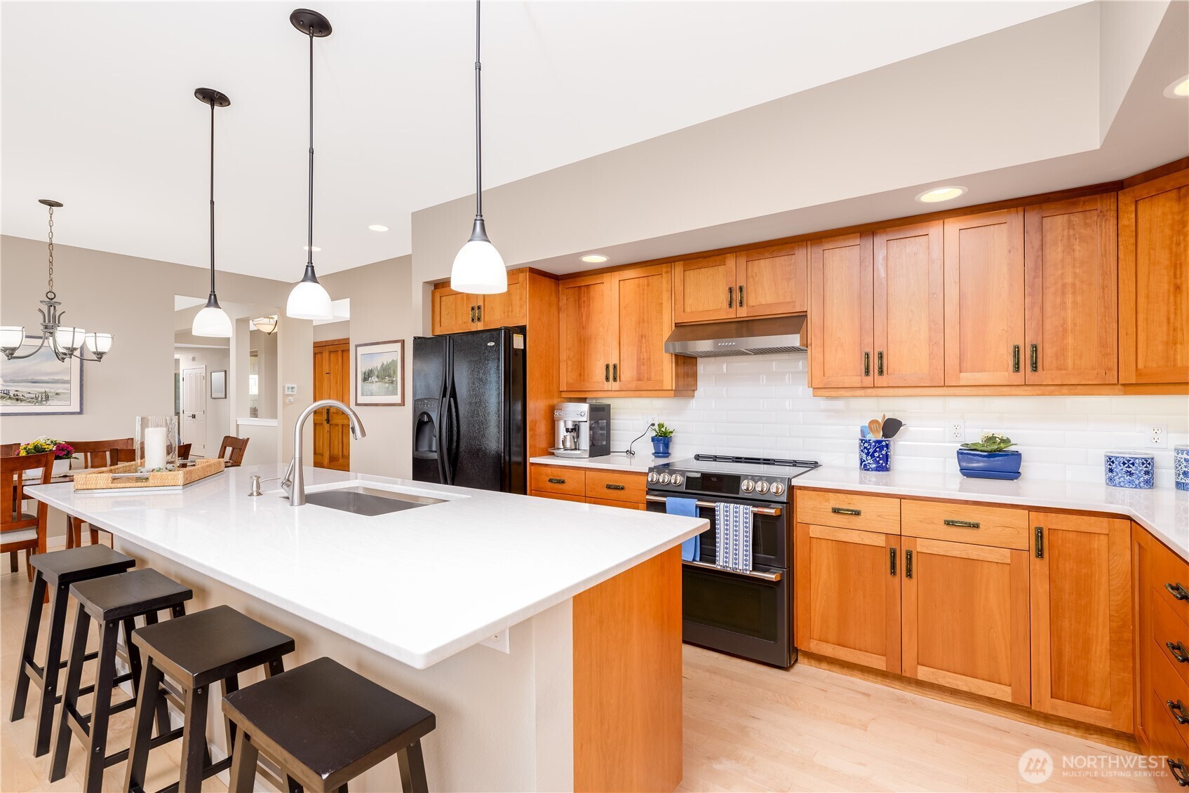 771 Brigadoon Boulevard Sequim, WA 98382 - Photo 21 of 40 a kitchen with stainless steel appliances kitchen island a table chairs and a refrigerator