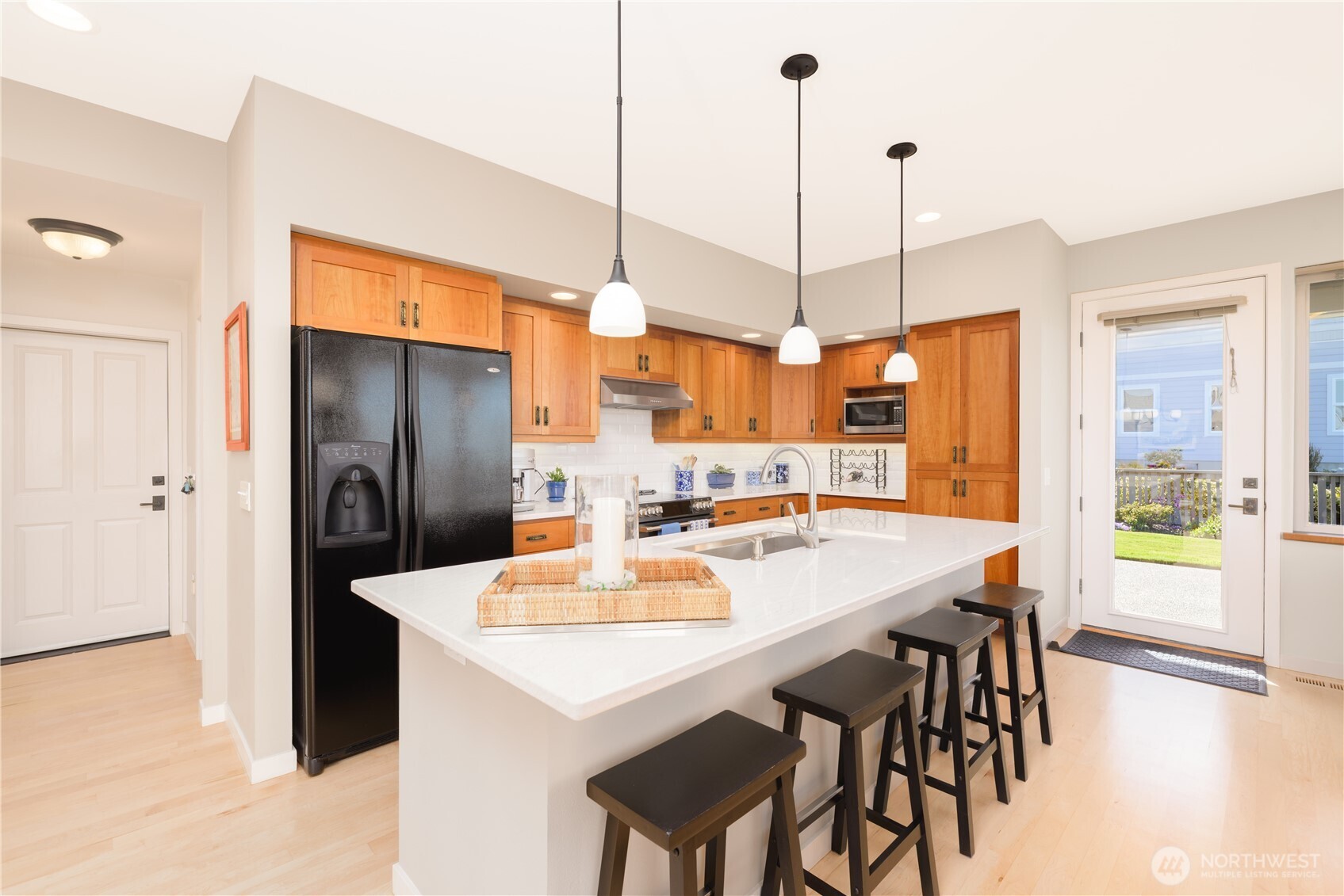 771 Brigadoon Boulevard Sequim, WA 98382 - Photo 22 of 40 a kitchen with stainless steel appliances kitchen island granite countertop a refrigerator a sink a stove and white cabinets with wooden floor