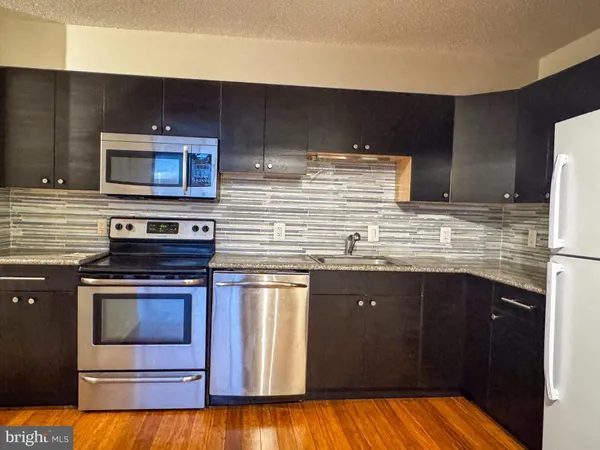 a kitchen with stainless steel appliances wooden cabinets and a stove top oven