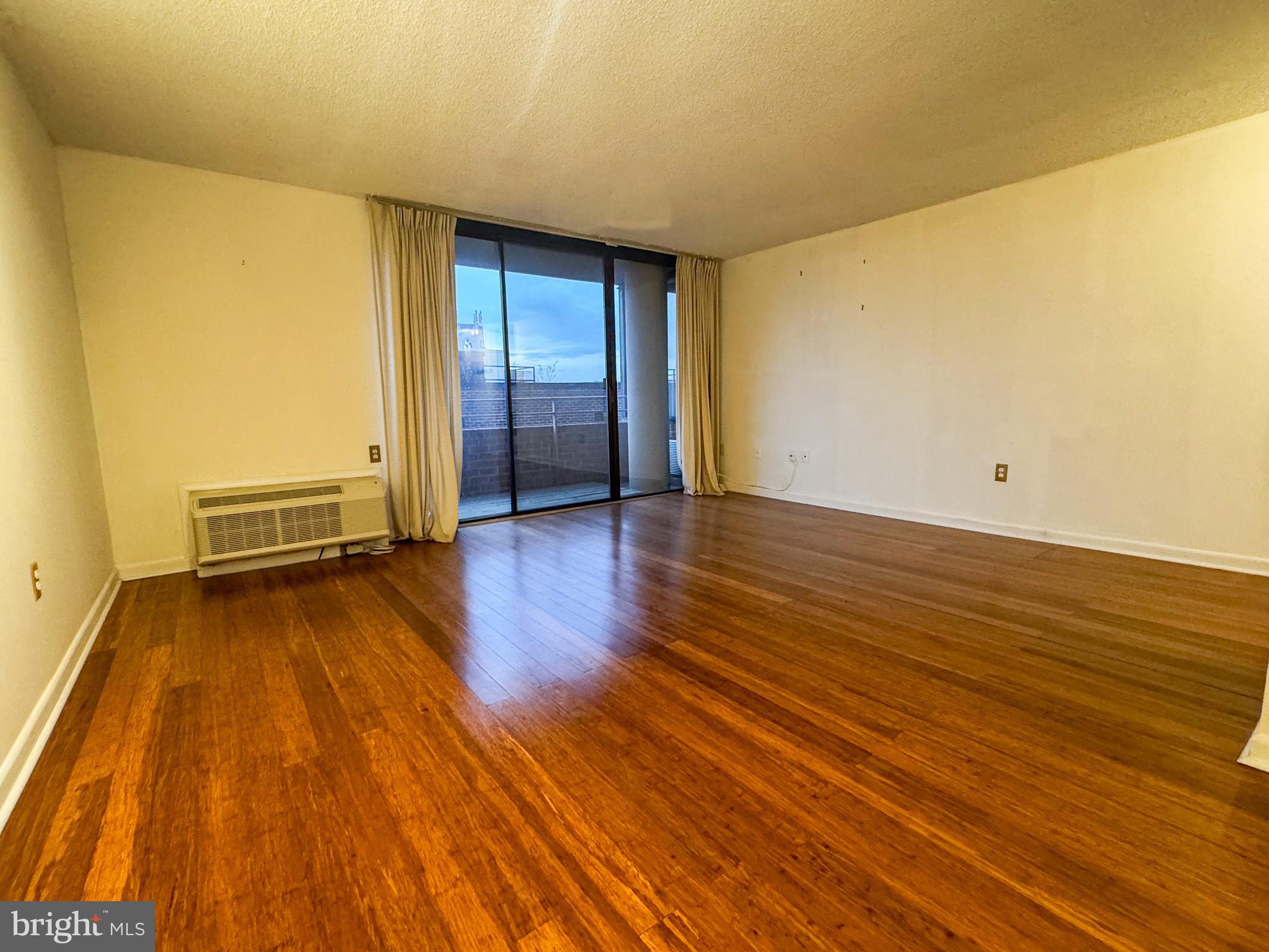 2141 P Street Northwest, Unit 705 Washington, DC 20037 - Photo 4 of 22 a view of an empty room with wooden floor and a window