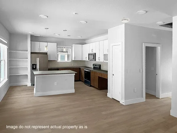 a view of kitchen with stainless steel appliances granite countertop a stove top oven a refrigerator a sink and a refrigerator