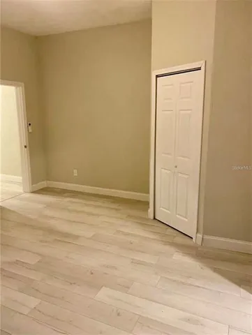 an empty room with wooden floor and closet