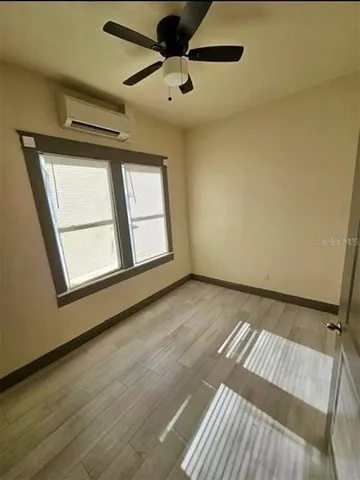 a view of a hallway with wooden floor and chandelier