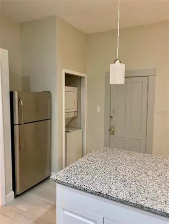a bathroom with a granite countertop sink and a refrigerator