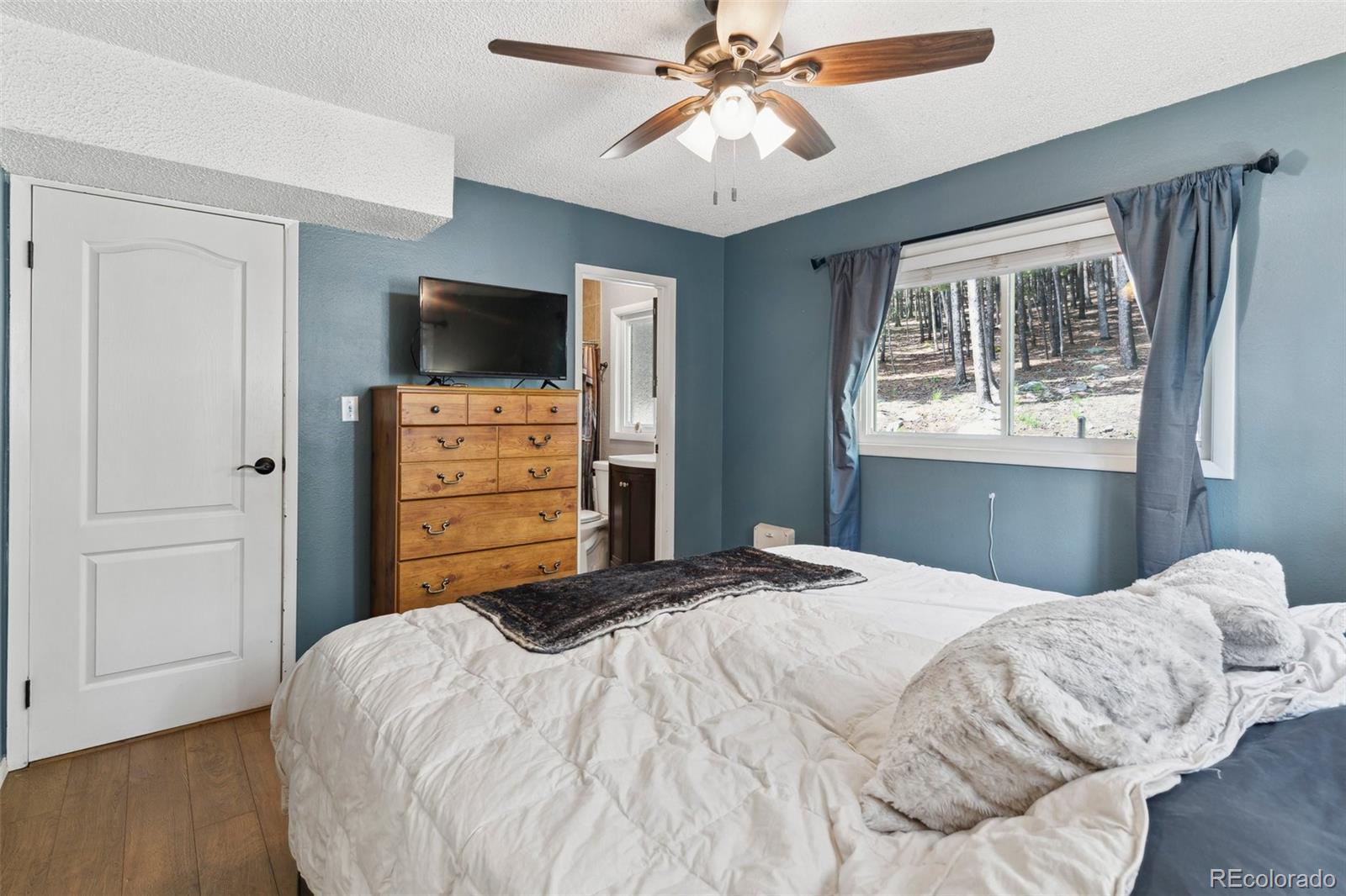 10807 Timothys Drive Conifer, CO 80433 - Photo 19 of 39 a bedroom with a bed and a flat screen tv