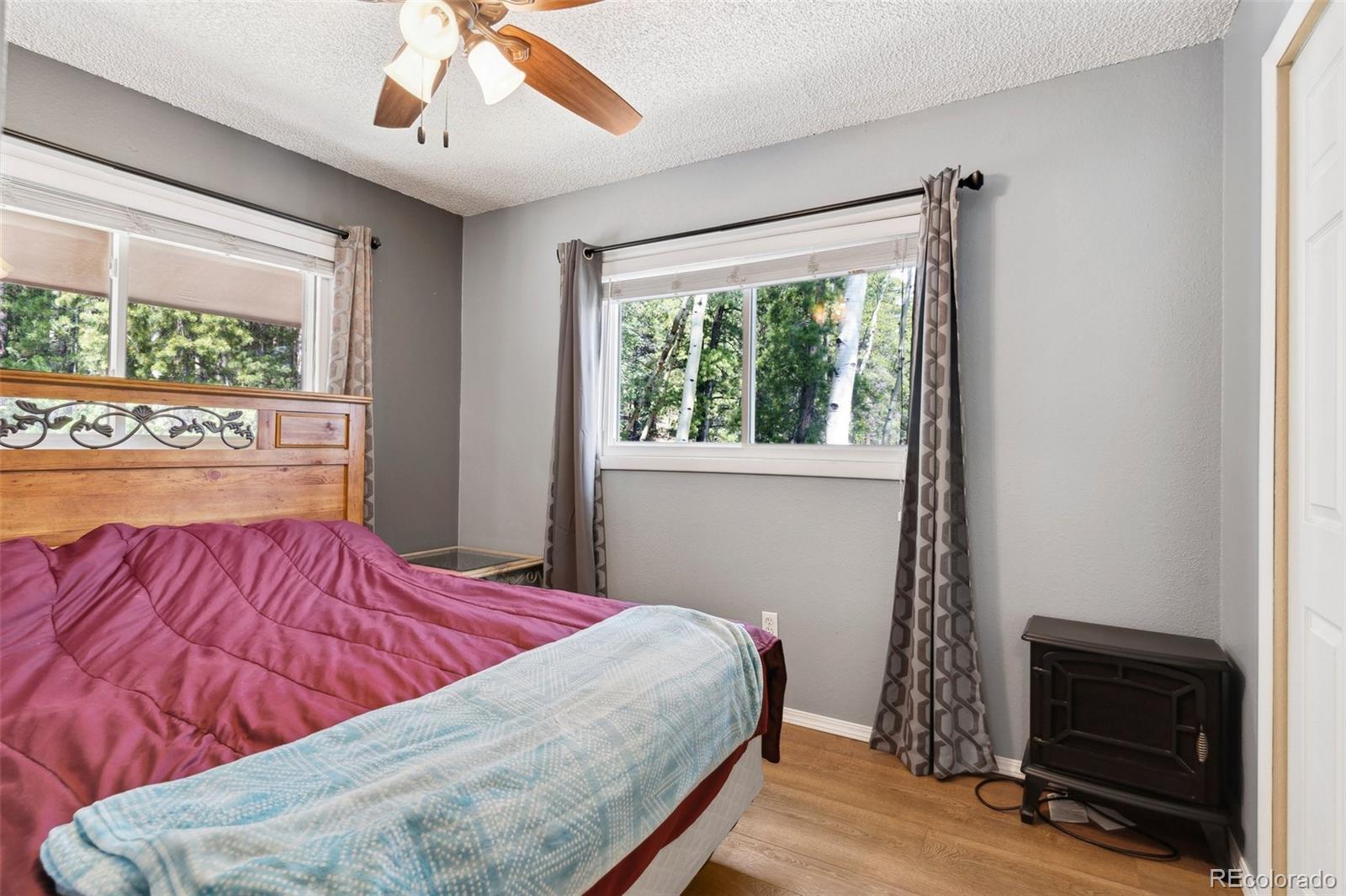 10807 Timothys Drive Conifer, CO 80433 - Photo 24 of 39 a bedroom with a bed and a fireplace