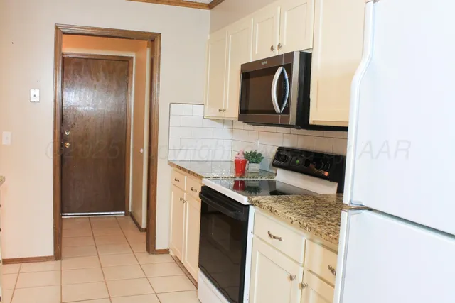 a kitchen with granite countertop a refrigerator and a stove