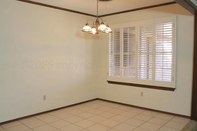 a view of a livingroom with a chandelier fan and window