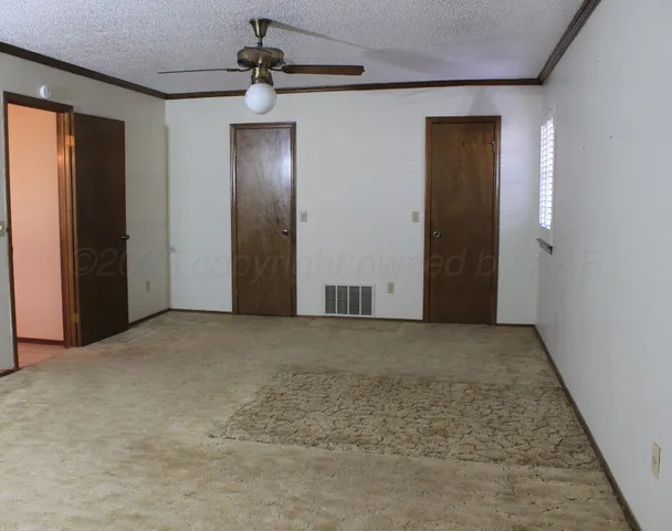 an empty room with fan and entrance