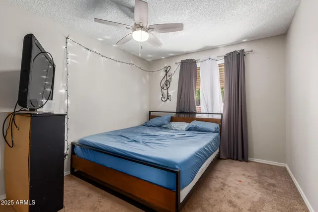 a bedroom with a bed and a flat tv screen on wall