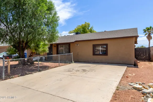 a backyard of a house with table and chairs