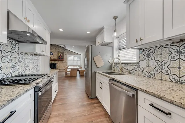 a kitchen with stainless steel appliances granite countertop a stove a sink and a microwave