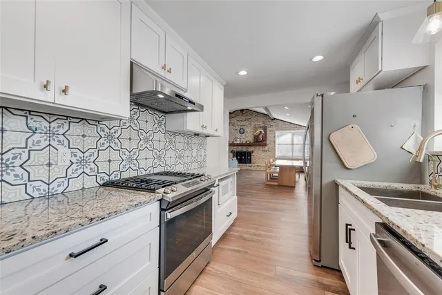 a kitchen with stainless steel appliances granite countertop a stove and a sink