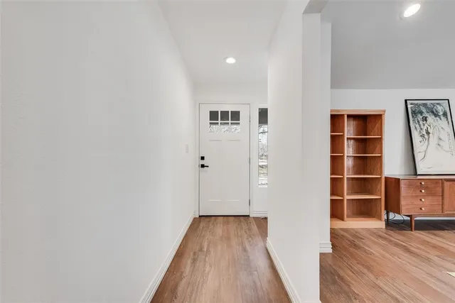 a view of a hallway with wooden floor and closet