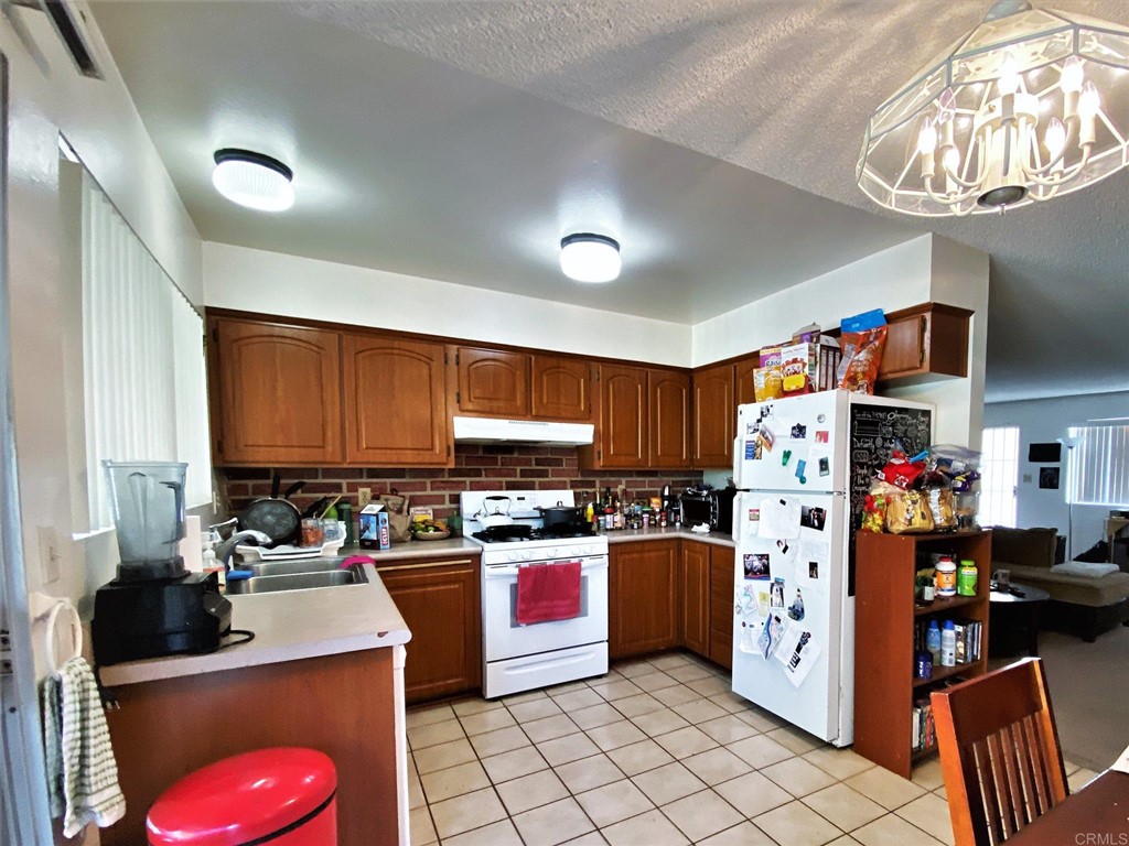 1121 Gardena Road Encinitas, CA 92024 - Photo 11 of 15 a kitchen with stainless steel appliances a refrigerator sink and cabinets