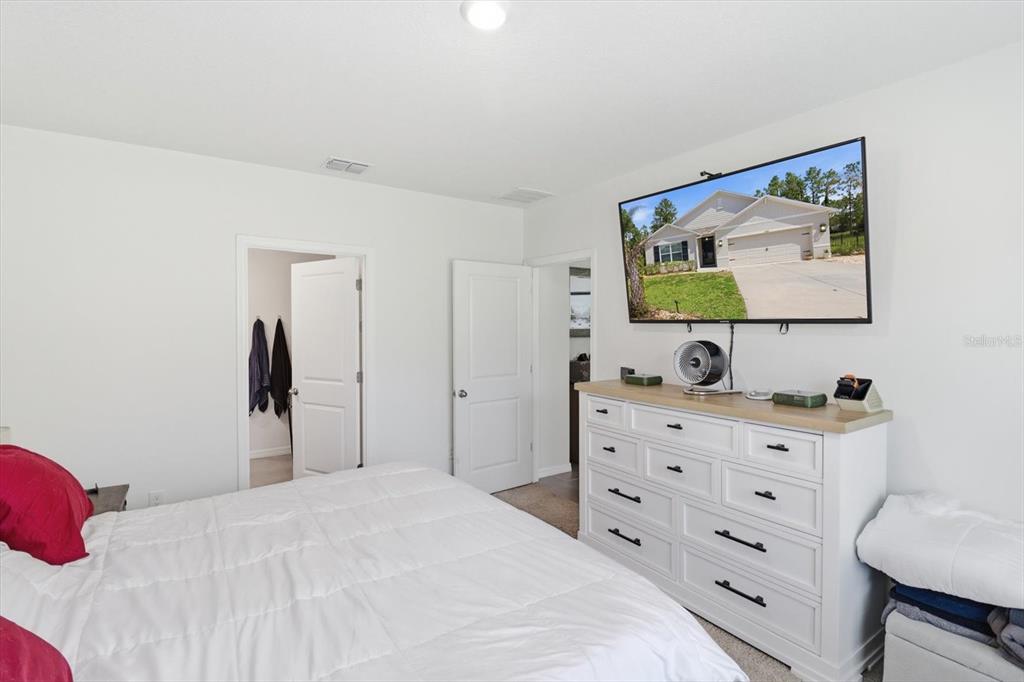 660 Hickory Course Loop Ocala, FL 34472 - Photo 29 of 45 a bedroom with a bed and a flat screen tv