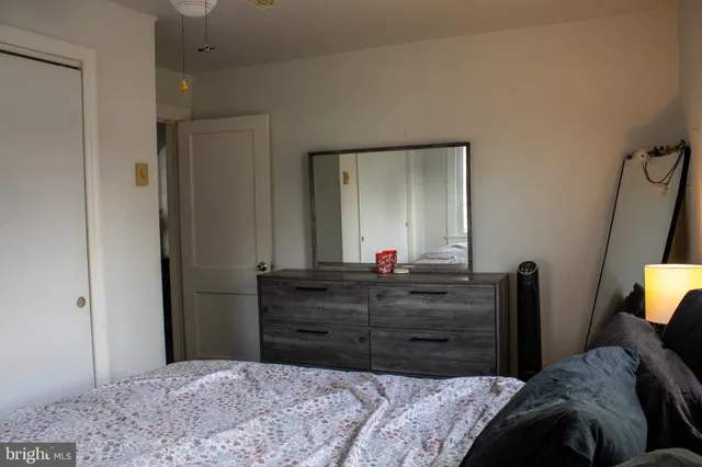 a bedroom with a bed and a mirror on dresser
