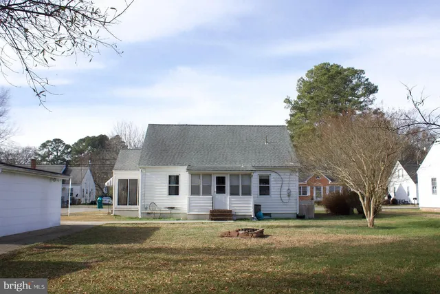 a front view of a house with a garden and trees