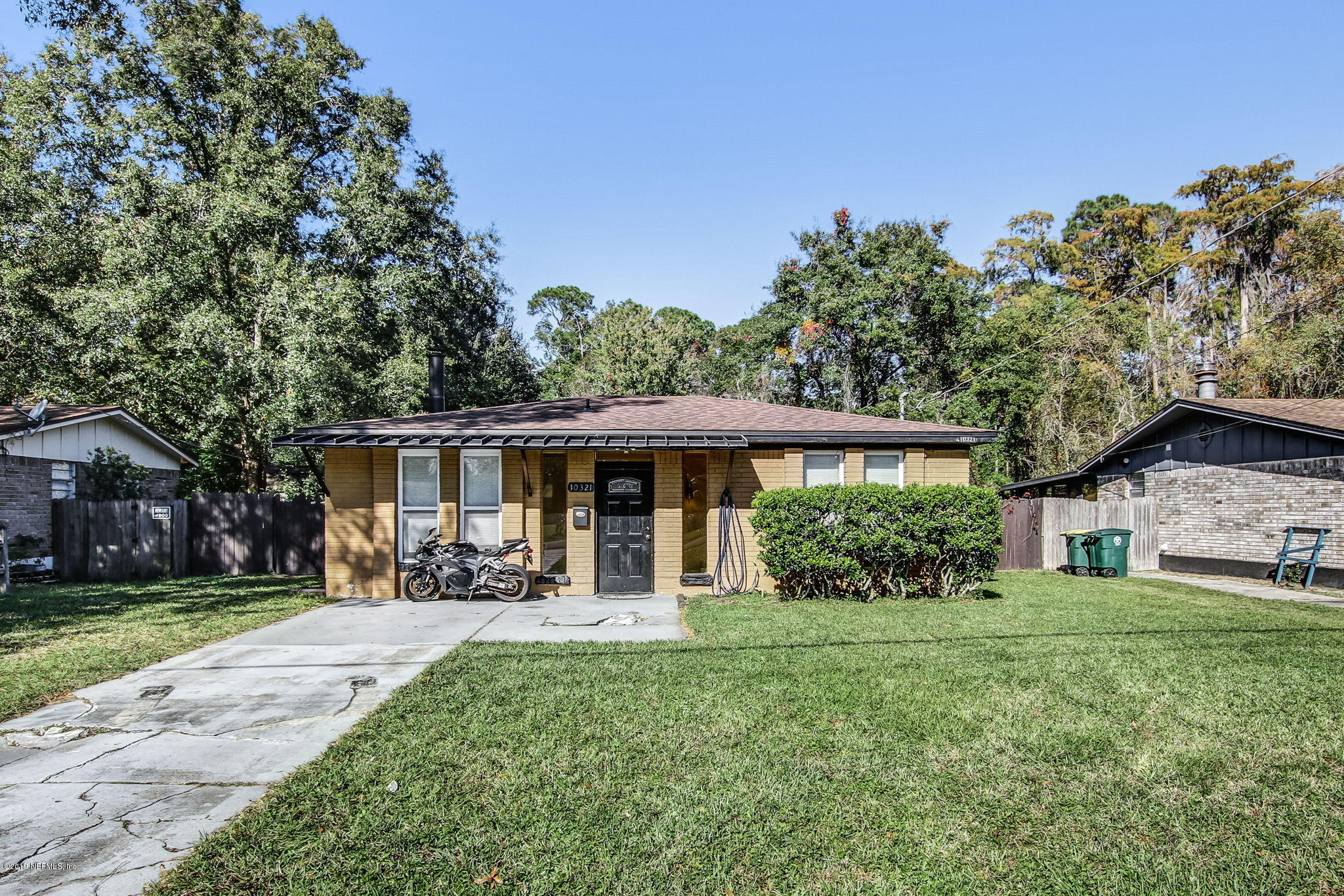 a front view of a house with a yard and trees