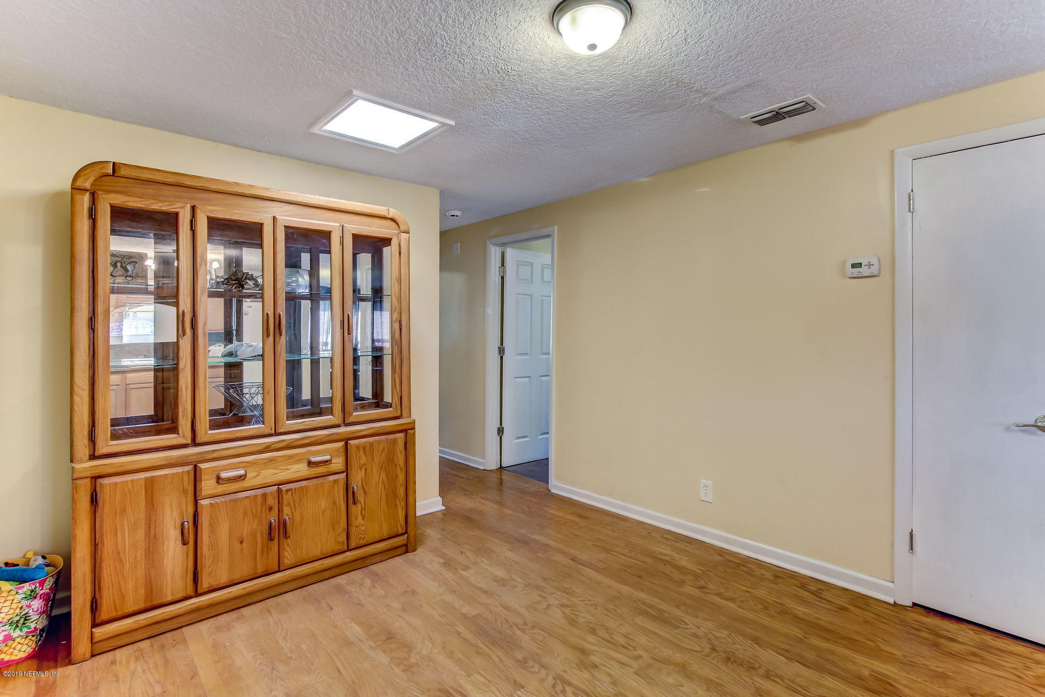 10321 Dobell Road Jacksonville, FL 32246 - Photo 16 of 34 an empty room with wooden floor cabinet and windows