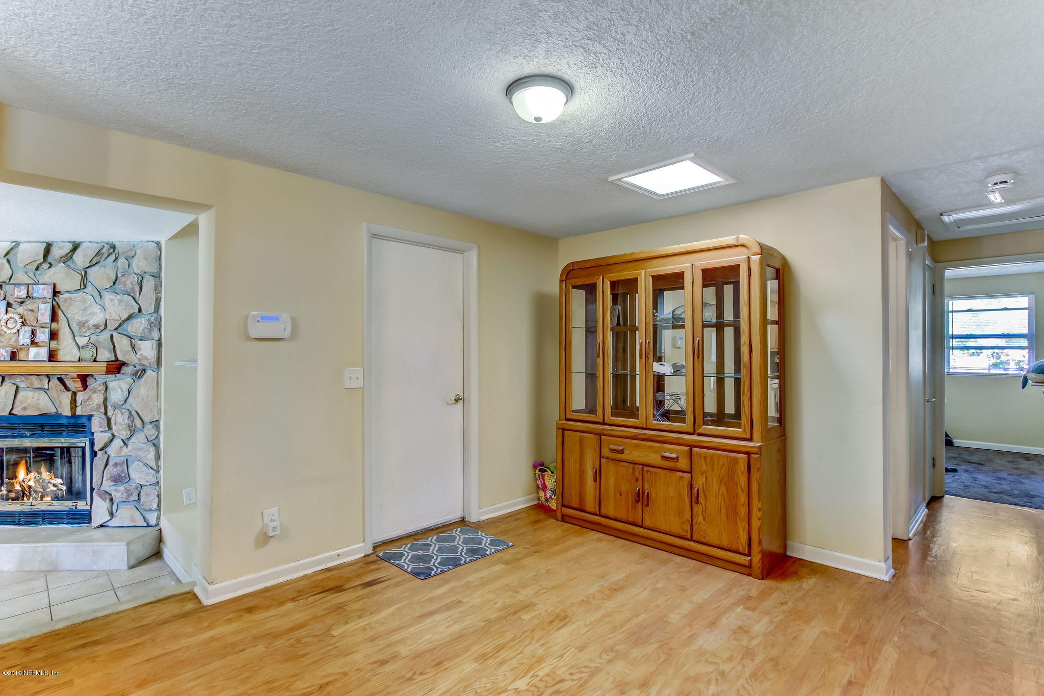 10321 Dobell Road Jacksonville, FL 32246 - Photo 17 of 34 an empty room with wooden floor and windows
