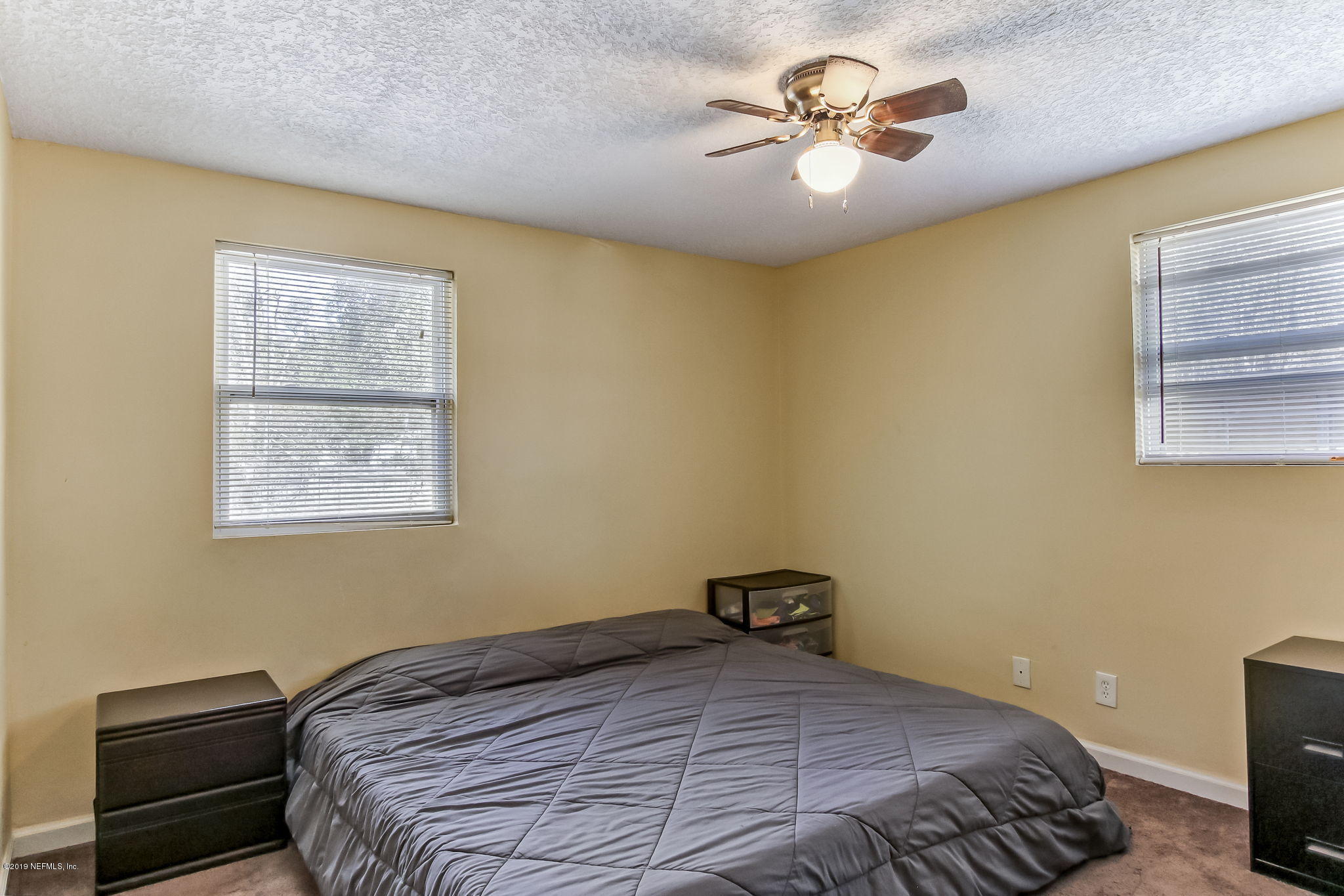 10321 Dobell Road Jacksonville, FL 32246 - Photo 18 of 34 a bedroom with a bed and a chandelier