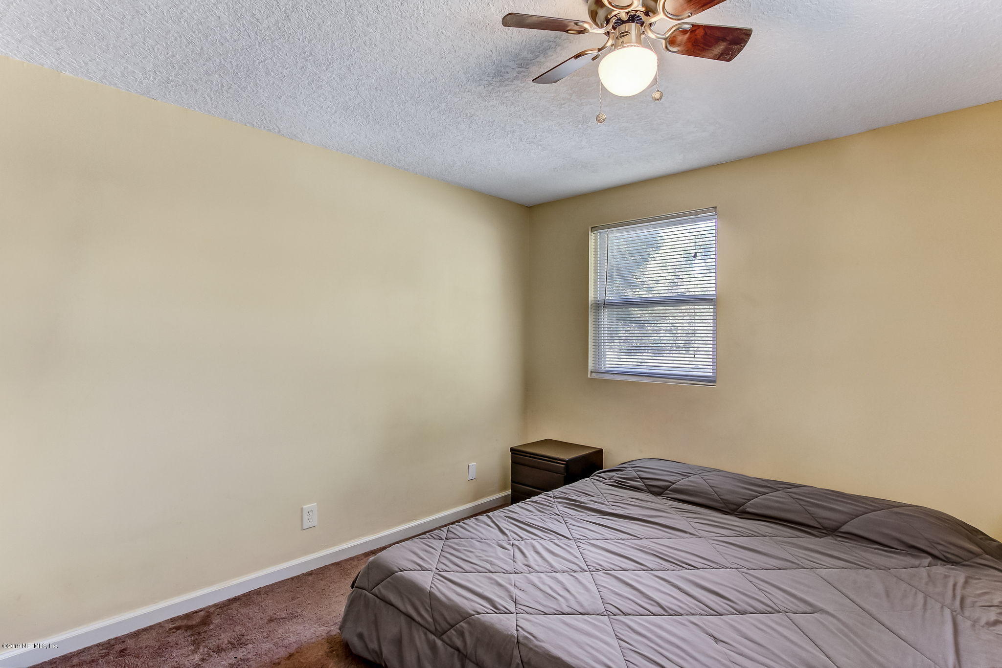10321 Dobell Road Jacksonville, FL 32246 - Photo 20 of 34 a bedroom with a bed and a chandelier