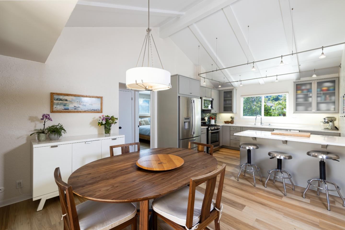 a kitchen with a dining table chairs and white cabinets