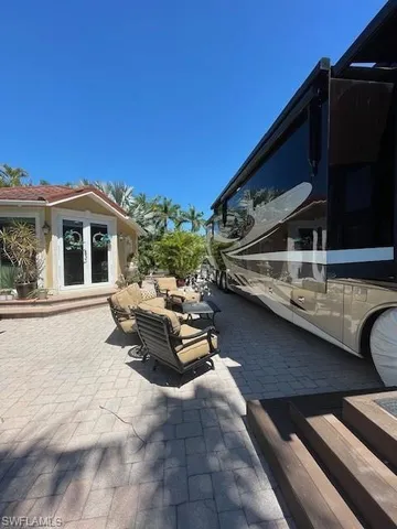 a roof deck with table and chairs and potted plants