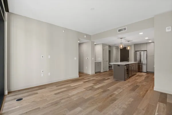 an empty room with chandelier fan and windows