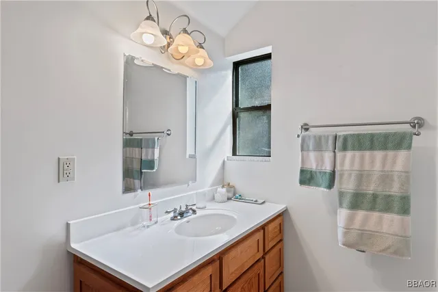 a bathroom with a sink a light fixture and a mirror