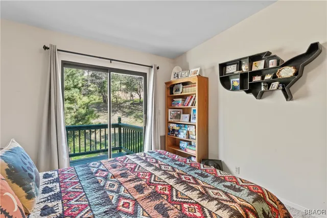 a bedroom with a bed a large window with the balcony view