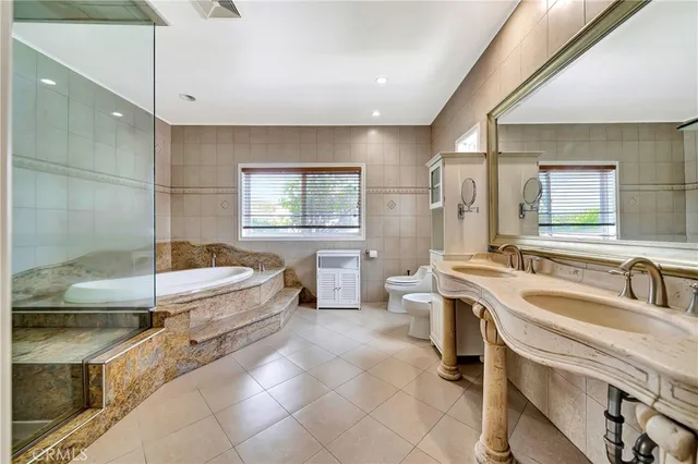 a spacious bathroom with a tub a sink and mirror