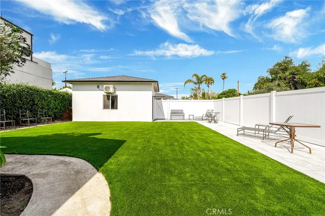 a view of a backyard with table and chairs and potted plants