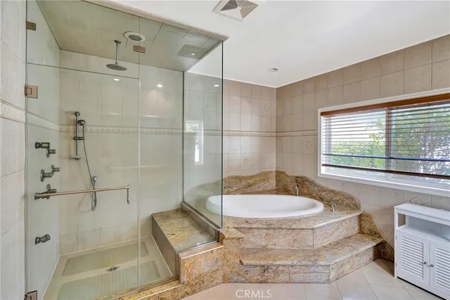 a bathroom with a tub a window and a shower