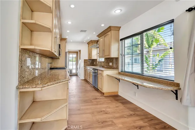 a large kitchen with stainless steel appliances granite countertop a large stove a sink and a refrigerator