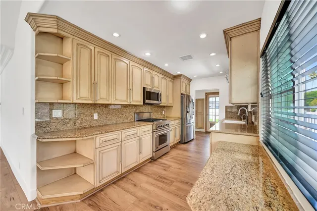 a large kitchen with stainless steel appliances granite countertop a stove and a refrigerator