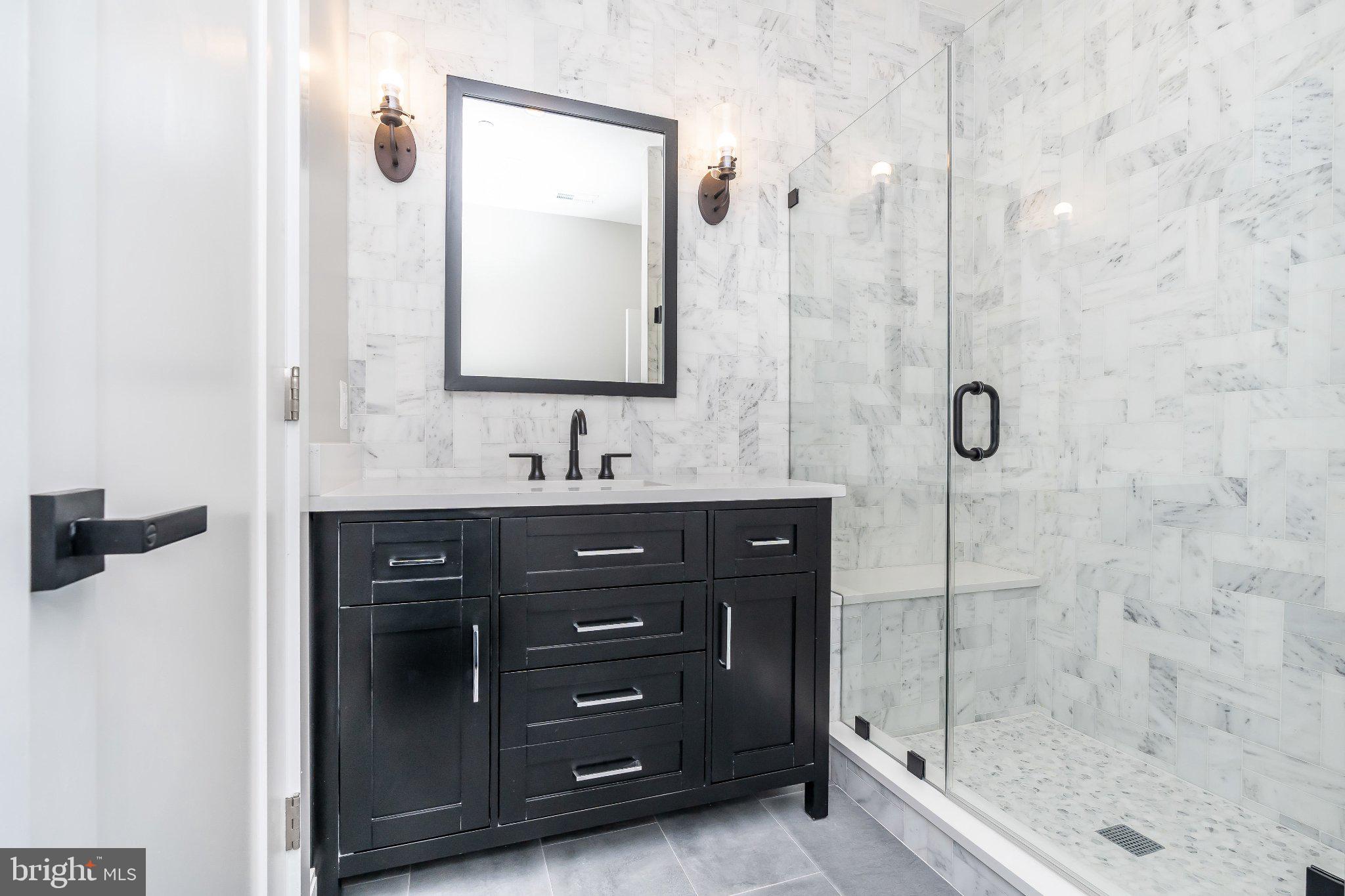 623 South Rose Street Baltimore, MD 21224 - Photo 7 of 12 a bathroom with a granite countertop sink a mirror and shower
