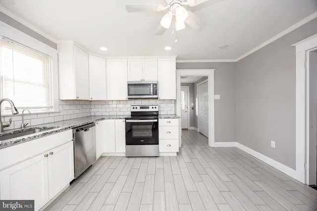 a kitchen with granite countertop a stove top oven microwave and cabinets