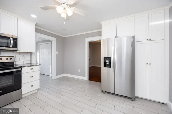 a large kitchen with granite countertop a stove top oven a sink dishwasher and a refrigerator with wooden floor