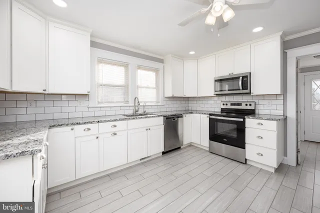 a view of empty room with wooden floor and ceiling fan