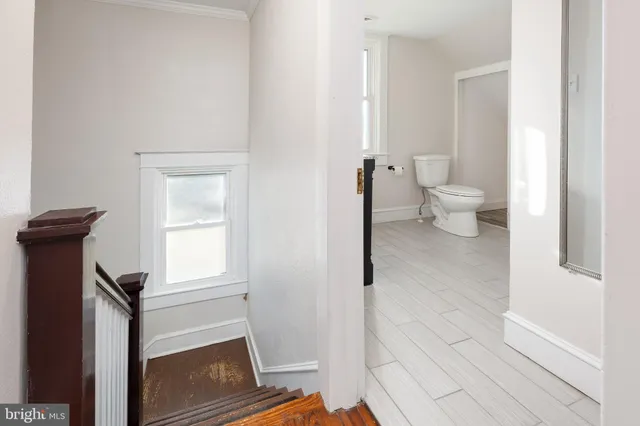 an empty room with wooden floor chandelier fan and closet area